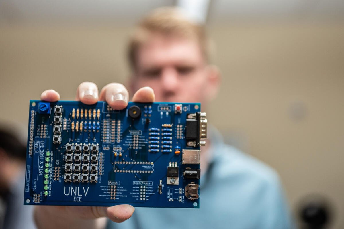 A man holding up a circuit board